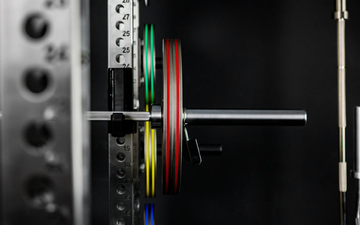 Front shot of Rep Fitness Calibrated Steel Plates (LB) loaded on a barbell, highlighting their thin width