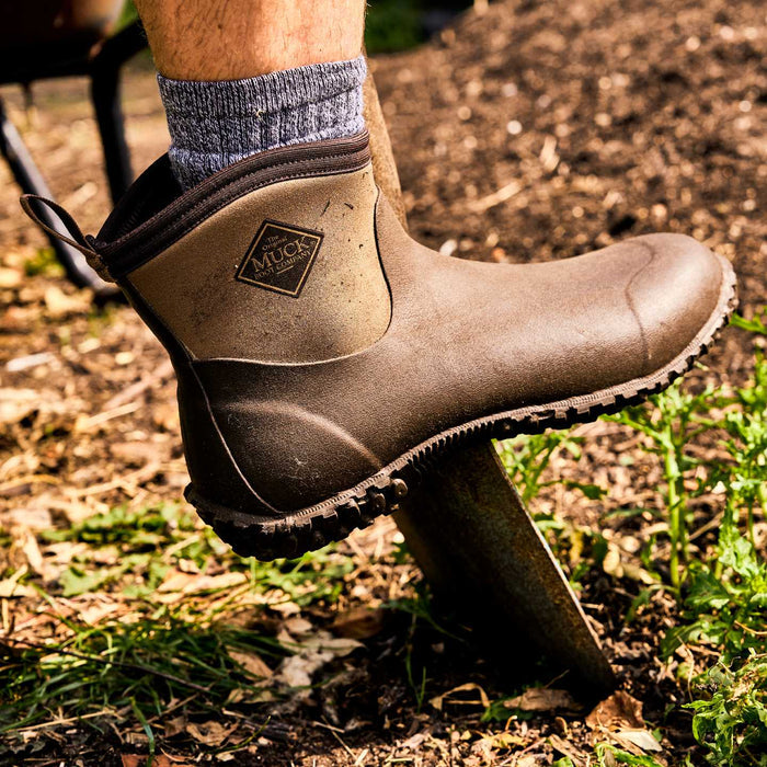M2A900 Muckster II Men's rubber muck boot worn outdoors on a grassy area
