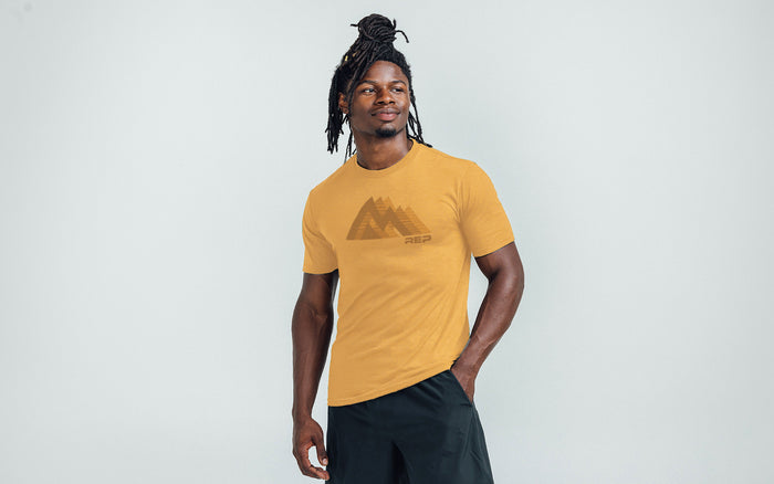 The REP Fitness Summit Tri-Blend Crew T-Shirt in Heather Ochre/Brown front, on model