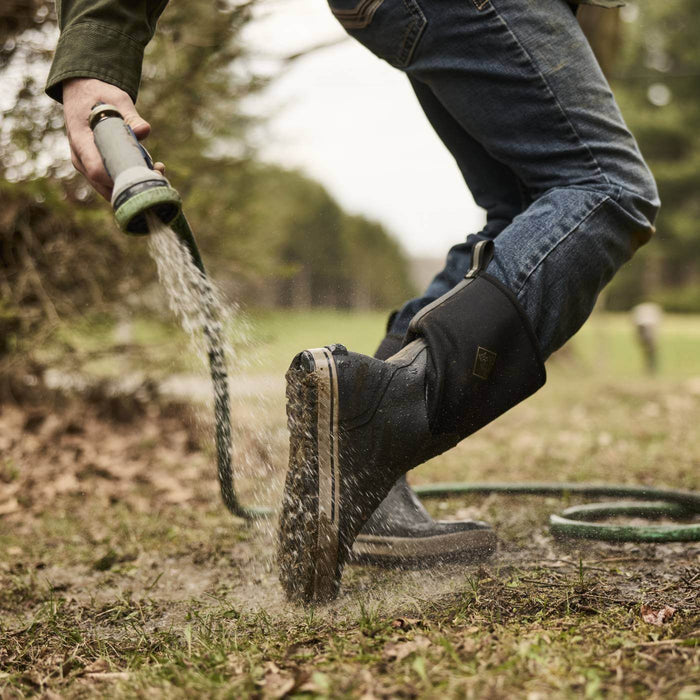 MXP12M00 Person rinsing off Xplorer 12" Men's Waterproof Outdoor Boots with hose showing the outsole.