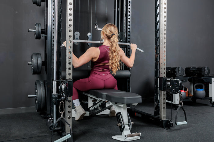 Athlete using the REP Fitness Altitude™ Leg Roller as a leg restraint while doing lat pulldowns