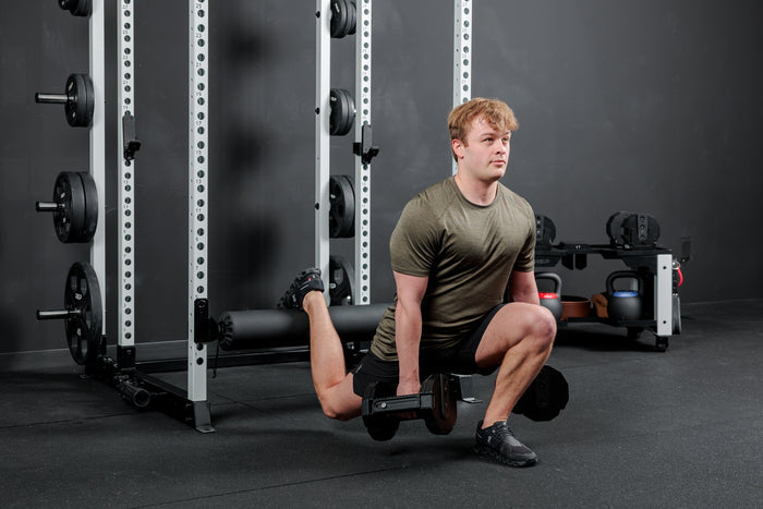 Athlete using the REP Fitness Altitude™ Leg Roller as a leg rest while doing dumbbell split squats