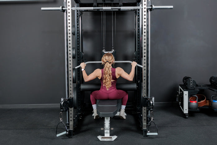Athlete doing lat pulldowns while using the REP Fitness Altitude™ Leg Roller as a leg restraint