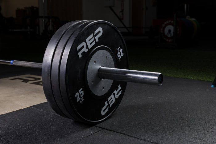 Black Competition Bumper Plates (LB) loaded onto a barbell