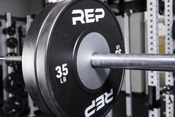 Black Competition Bumper Plates (LB) loaded onto a barbell