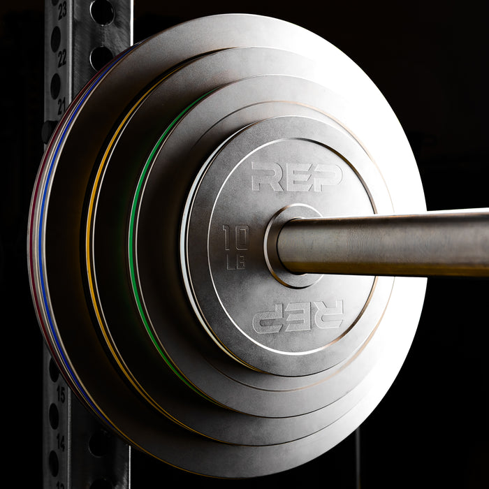 REP Fitness Calibrated Steel Plates in LB loaded onto a barbell on a PR-5000 rack