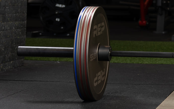 Rep Fitness Calibrated Steel Plates (LB) loaded onto a barbell