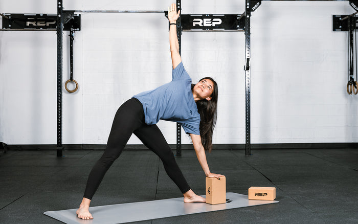 Athlete performing a yoga pose with REP's cork yoga blocks.
