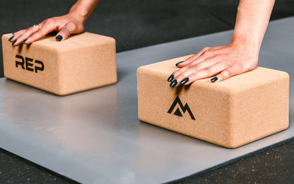 up close of hands on yoga blocks cork