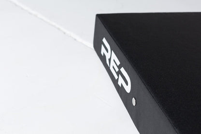 Angled view of the top and side of a REP Crash Pad showing the white "REP' logo and an exhaust vent.