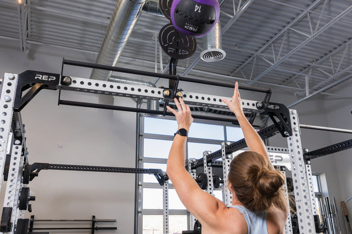Athlete doing wall balls on the REP Fitness Crossmember Mount Wall Ball Target