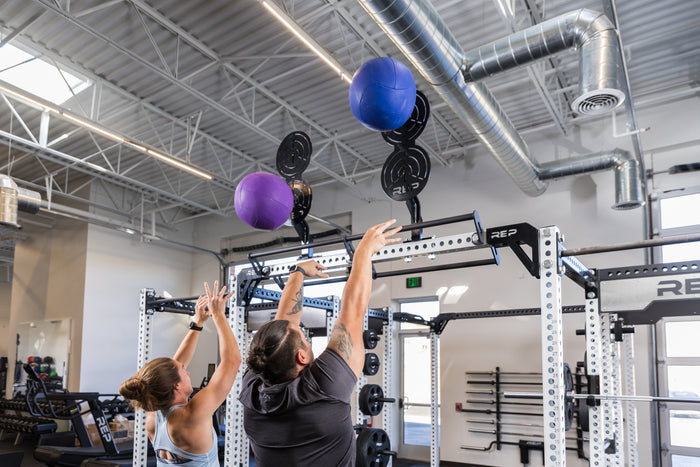 Two athletes doing wall balls on Crossmember Mount Wall Ball Targets