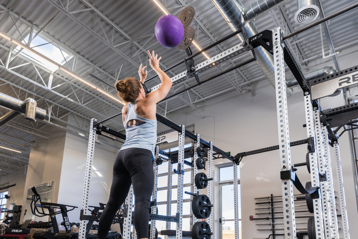Athlete doing wall balls on the REP Fitness Crossmember Mount Wall Ball Target