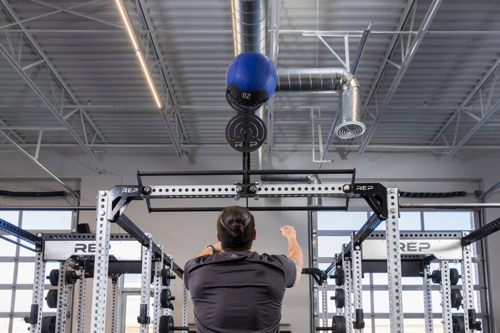 Athlete doing wall balls on the REP Fitness Crossmember Mount Wall Ball Target
