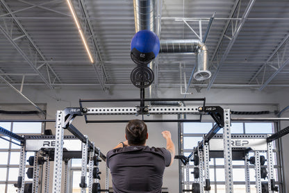Athlete doing wall balls on the REP Fitness Crossmember Mount Wall Ball Target