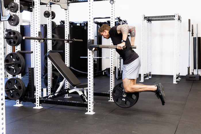 Athlete doing weighted dips on the REP Fitness Dip Attachment 2.0