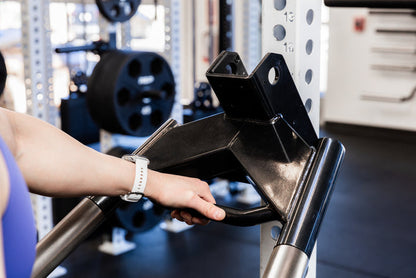 Athlete installing the REP Fitness Dip Attachment 2.0 on a 5000 series power rack