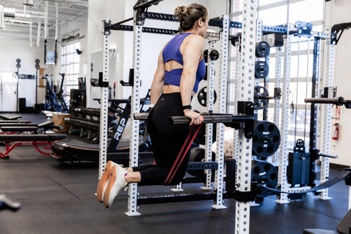 Athlete doing assisted dips with a resistance band on the REP Fitness Dip Attachment 2.0