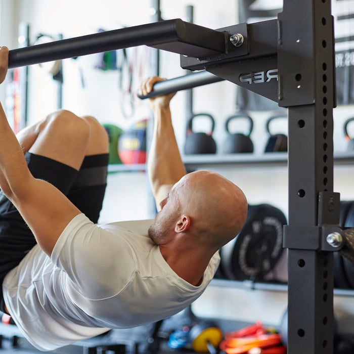 Athlete hanging from the REP Fitness Dip Station for the 4000 series