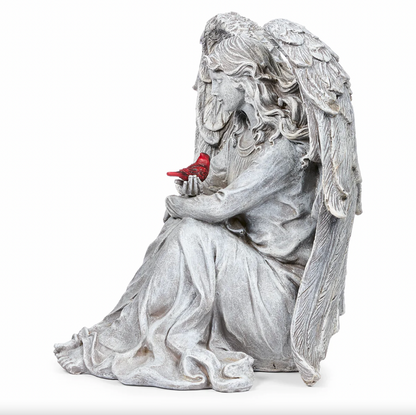 Statue of an angel holding a cardinal on a white background