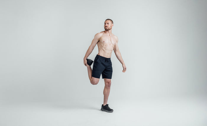 The REP Fitness Men's Apollo Shorts in Heather Navy/Cool Gray front, stretching