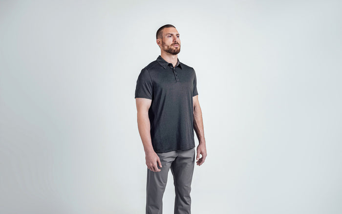 The REP Fitness Men's Audax Performance Polo in Heather Black/Cool Gray front, 3/4 angle