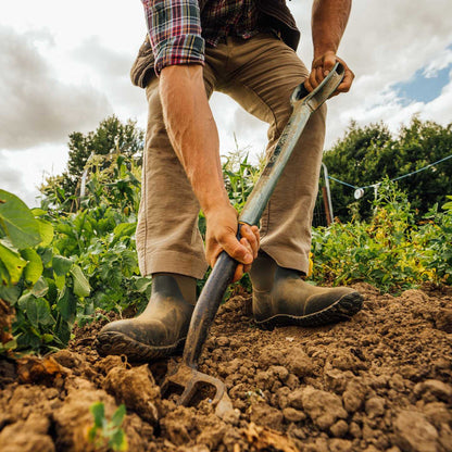 Person gardening with a tool in a field wearing M2A300 Muckster II Men's Ankle Muck Boot
