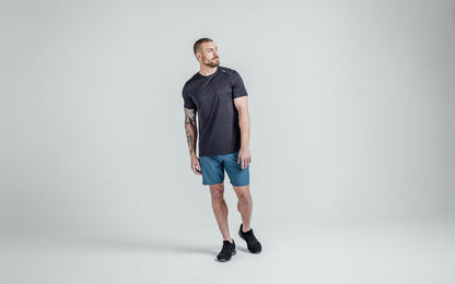 The REP Fitness Men's Sigmatech Shirt in Heather Black front, head turned to the side