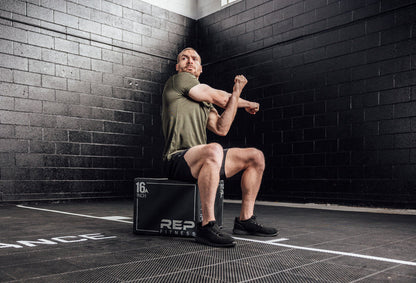 The REP Fitness Men's Sigmatech Shirt in Heather Olive front, stretching