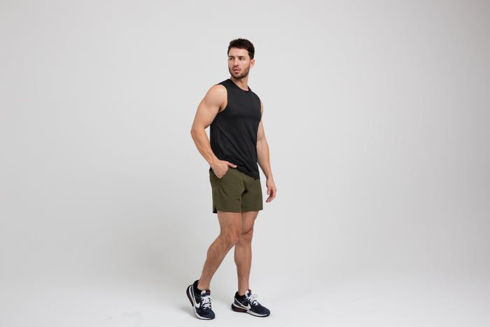 The REP Fitness Men's Solis Muscle Tee in Black front, side-profile walking