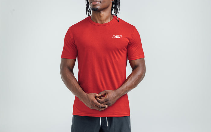 The REP Fitness Men's USA Tri-Blend Crew T-Shirt in Heather Red/White front, on model