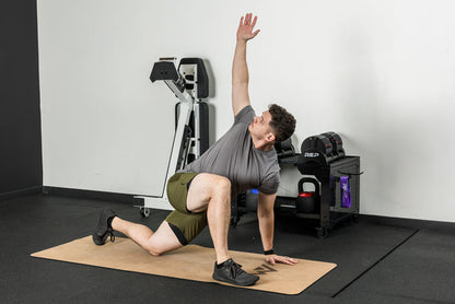 An athlete stretching on the REP premium cork yoga mat