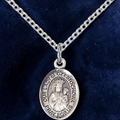 Silver pendant necklace on a dark blue fabric background