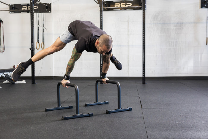 Athlete performing calisthenics on the REP Fitness Parallette Bars