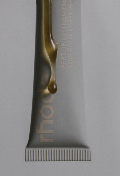 rhode peptide lip treatment - salted caramel, with product dripping down the tube