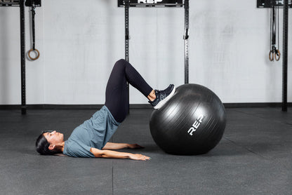 An athlete doing hamstring curls with the REP Physioball.