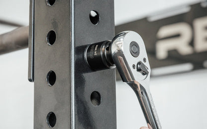 A ratchet wrench with REP's 24mm Rack Socket installing a bolt on a 4000 Series Power Rack