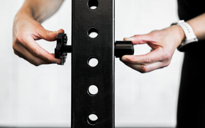 An athlete installing the magnet of the Rack Mounted REP® x Kleva Built® Adroit Landmine on a 4000 series rack