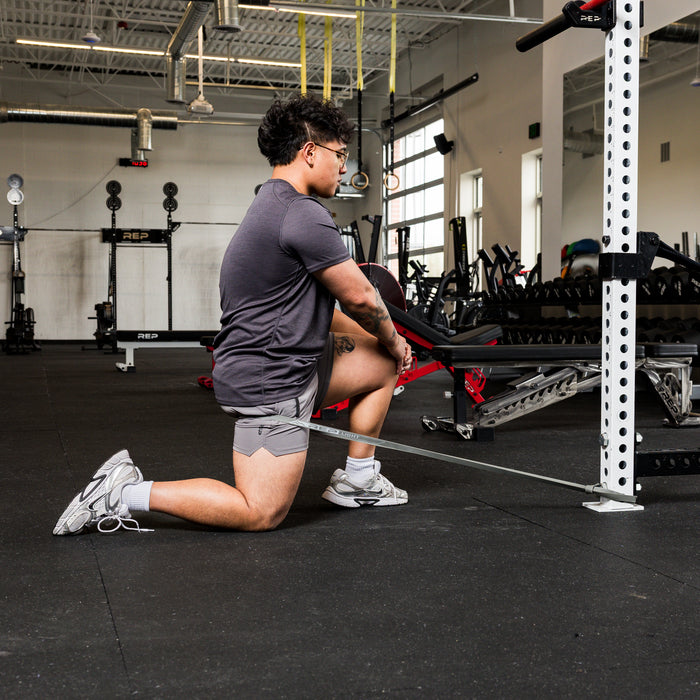 Athlete using the REP Fitness Resistance Bands 2.0 in half-kneeling row