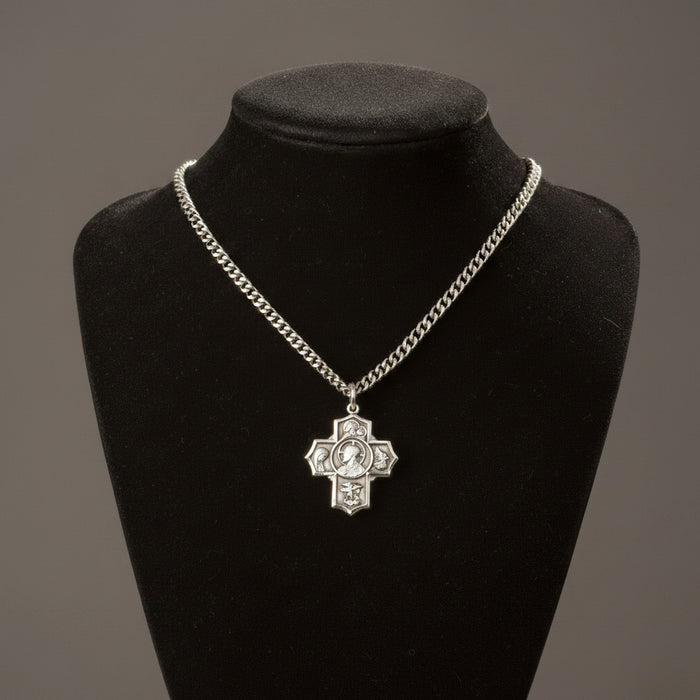 Silver chain necklace with a cross pendant on a black mannequin bust against a gray background