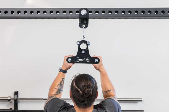 Athlete using the REP Fitness Shackle attached to a PR-5000 crossmember with a REP x Kleva Built close-grip attachment