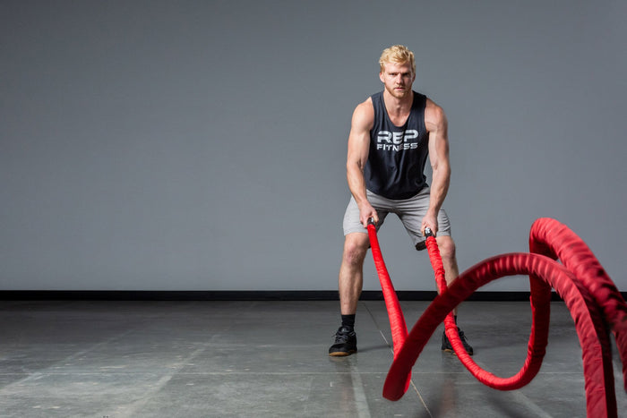 Exercising with red Battle Ropes