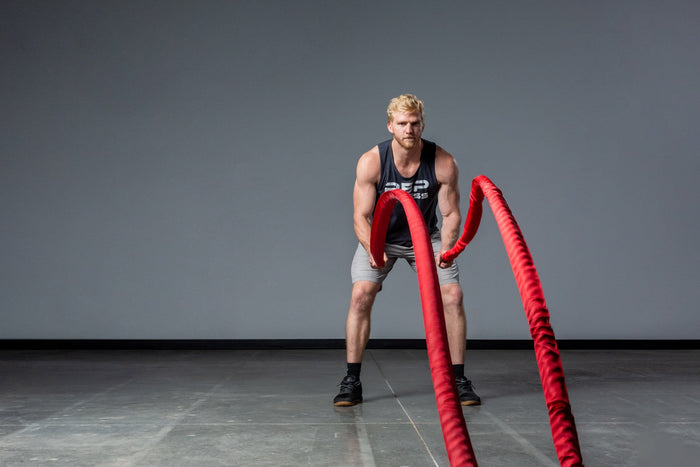 Exercising with red Battle Ropes