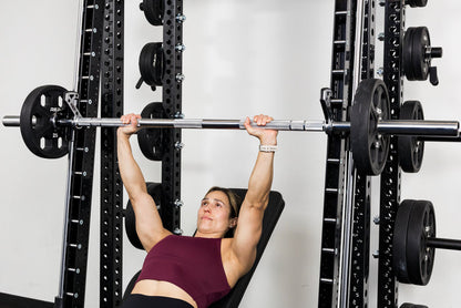 Athlete benching on the front of a rack mounted Smith Machine