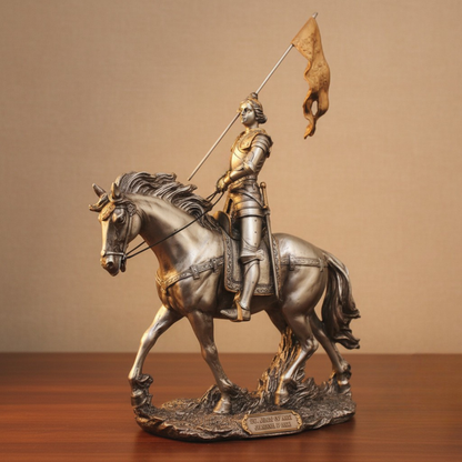Statue of St. Joan of Arc on horseback with a flag, displayed on a wooden surface.