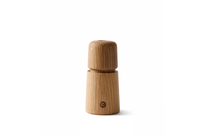 A beige oak wood manual grinder with a 'S' or 'P' indicator on the lid, designed for grinding salt, pepper, or spices.