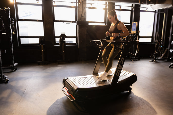 Athlete reverse sled walking with the belt squat belt on the Strive Curved Treadmill