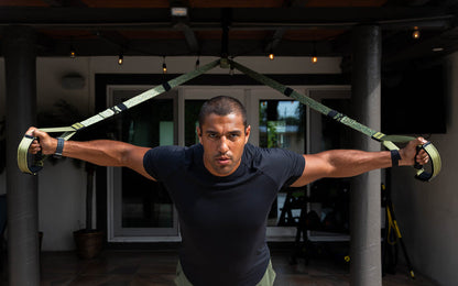 Action shot: Athlete using the TRX® Pro4 Suspension Trainer in Camo to perform a chest fly exercise