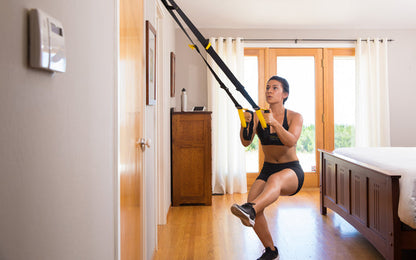 Action shot: Athlete working out with the TRX® STRONG System inside their bedroom