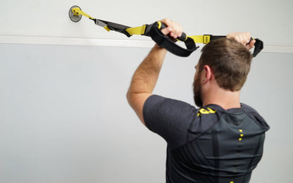 Action shot: Athlete working out on a TRX Suspension Trainer™ attached to a TRX X-Mount® on a home wall
